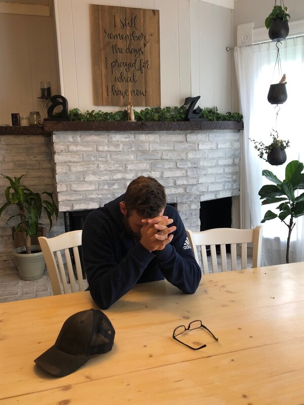 someone praying in front of a fireplace